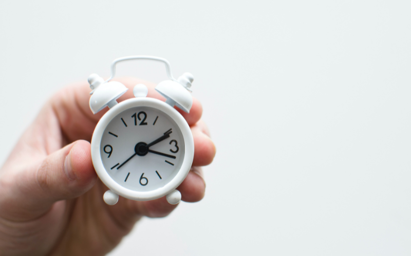Hand holding an alarm clock
