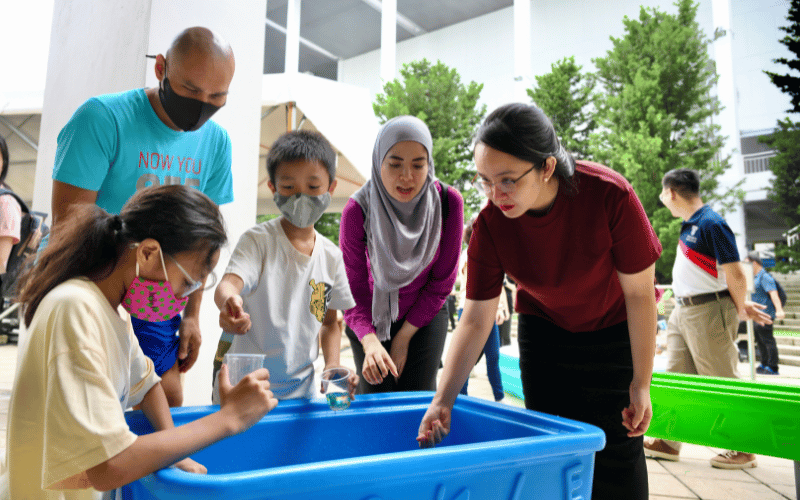 A lady educator is guiding the children how to play together with the parents