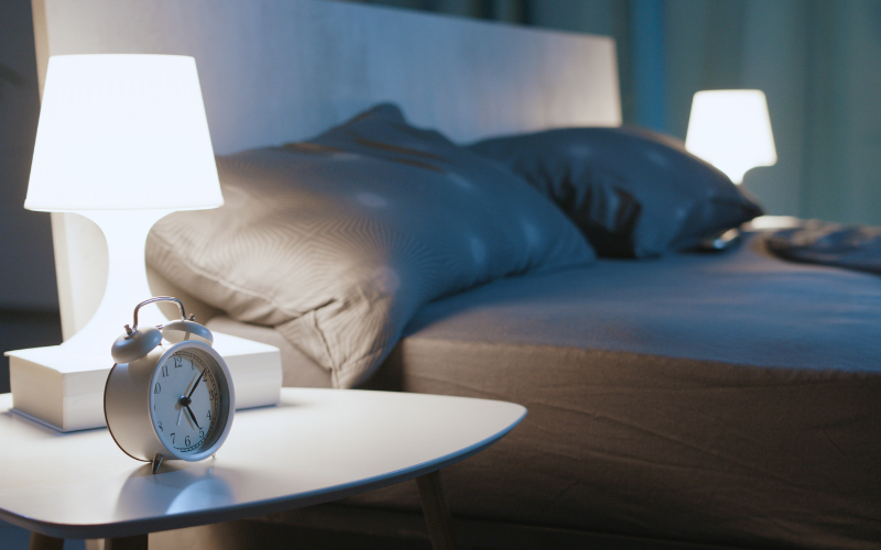 A bed at night with table lamps on either side