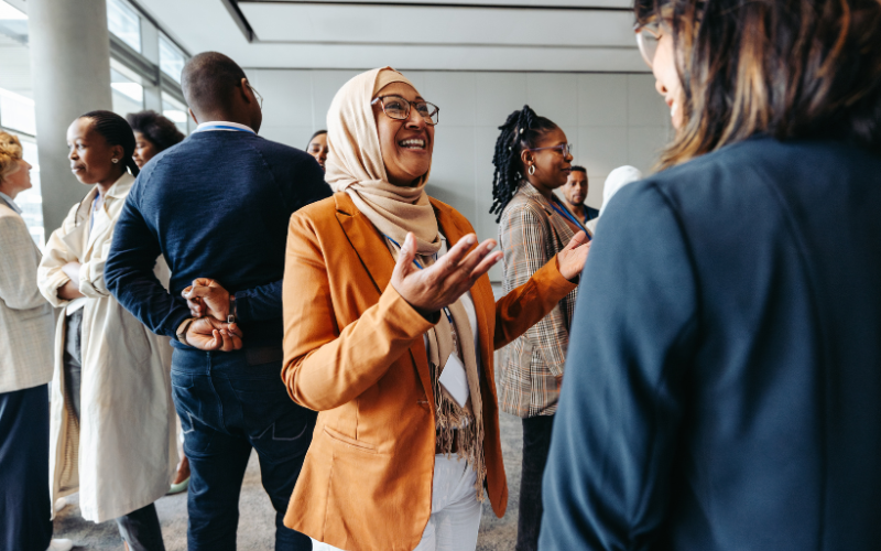 A woman confidently networking with other industry professionals at an event