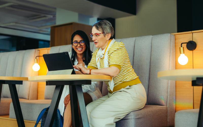 A student and a professor are engaging in discussion while looking at a laptop