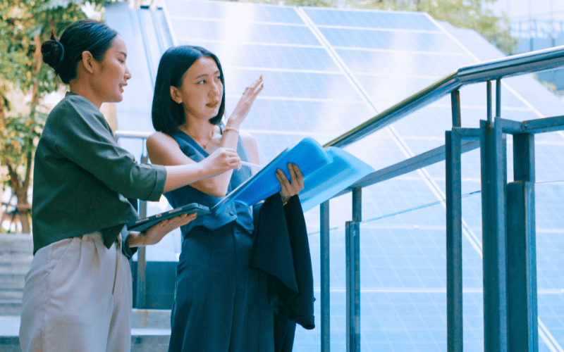 A female professional presenting building design concepts outdoors, capturing modern applications of heritage and sustainability