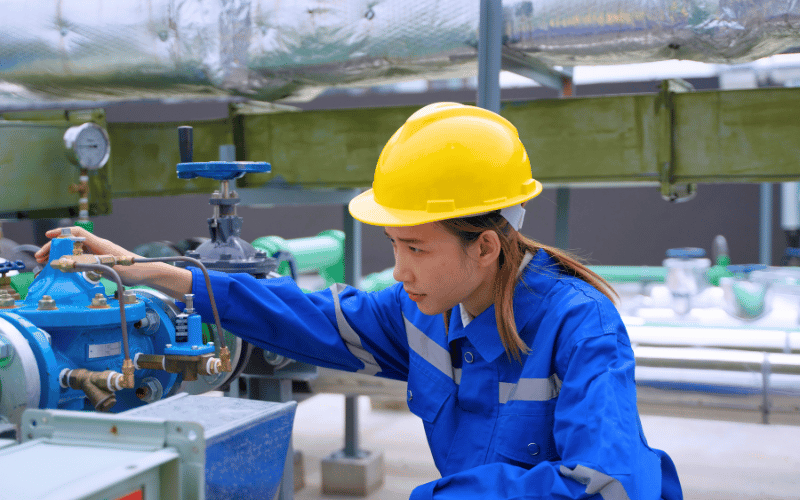 female engineer in blue collar evaluating AC system