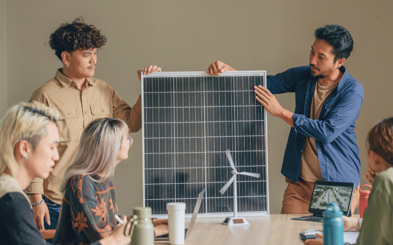 co-workers showing solar panel during meeting