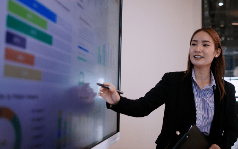 female working professional presents her findings on the screen