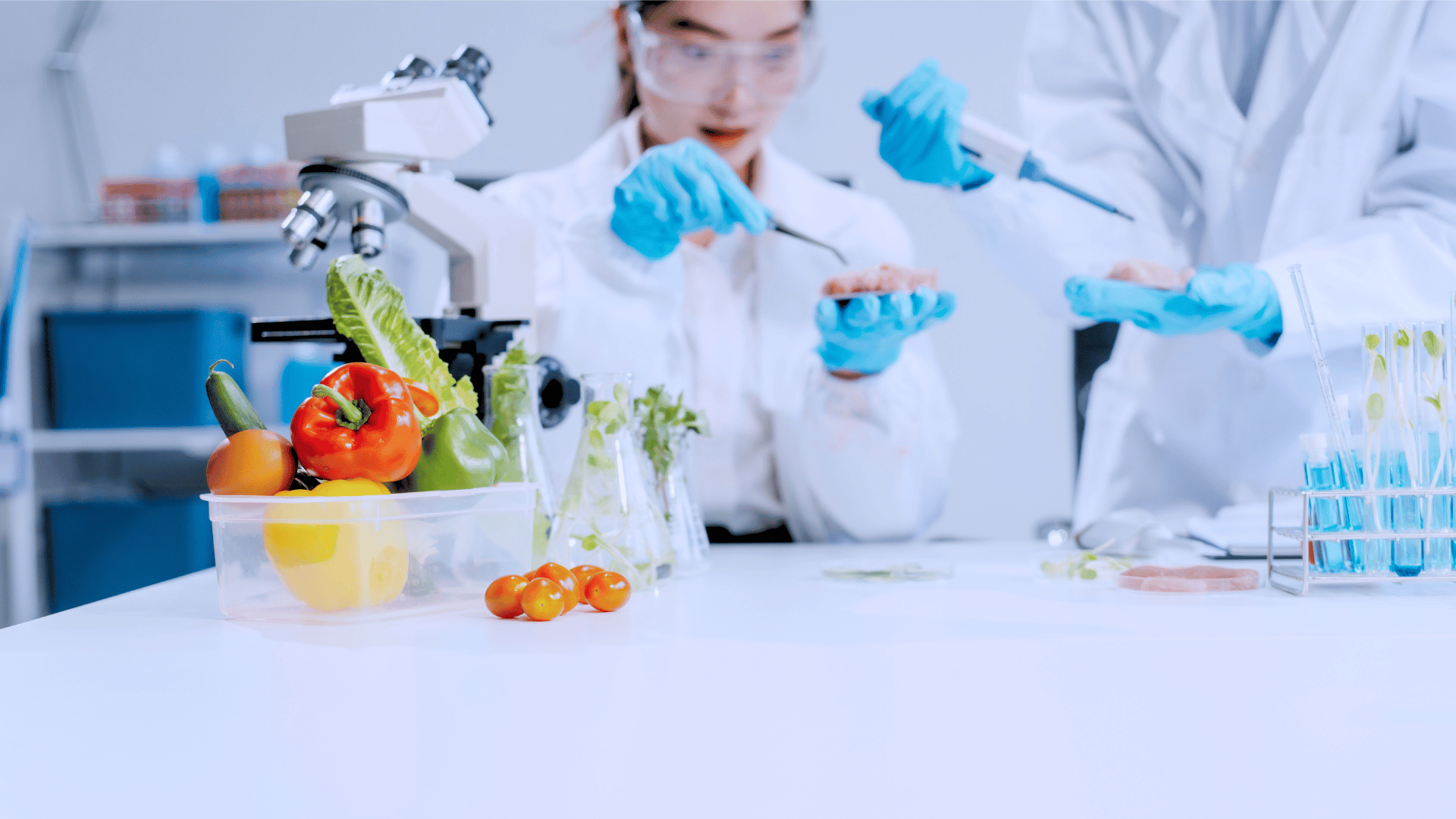 A food science researcher examining a sample in a lab, with fresh vegetables and lab equipment on the table.