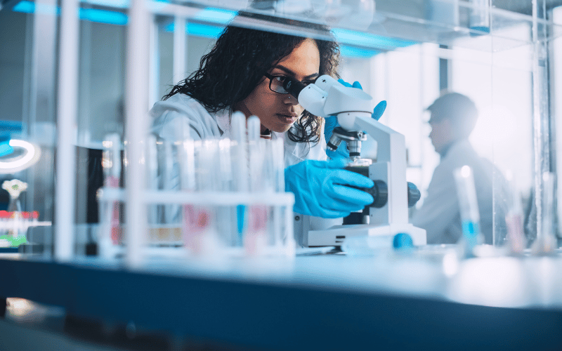 Scientist lady looks at the microscope