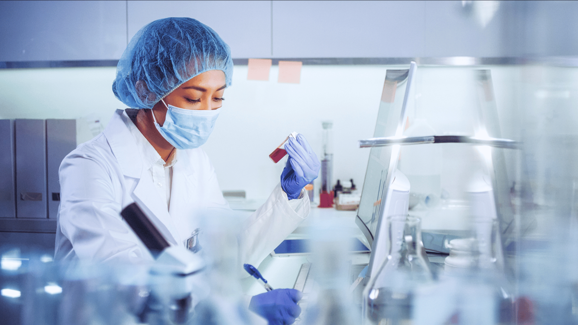 Female scientist records a test tube reading