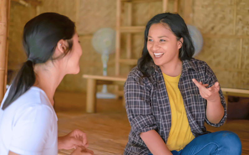 Two young women having a friendly conversation in a local cultural setting