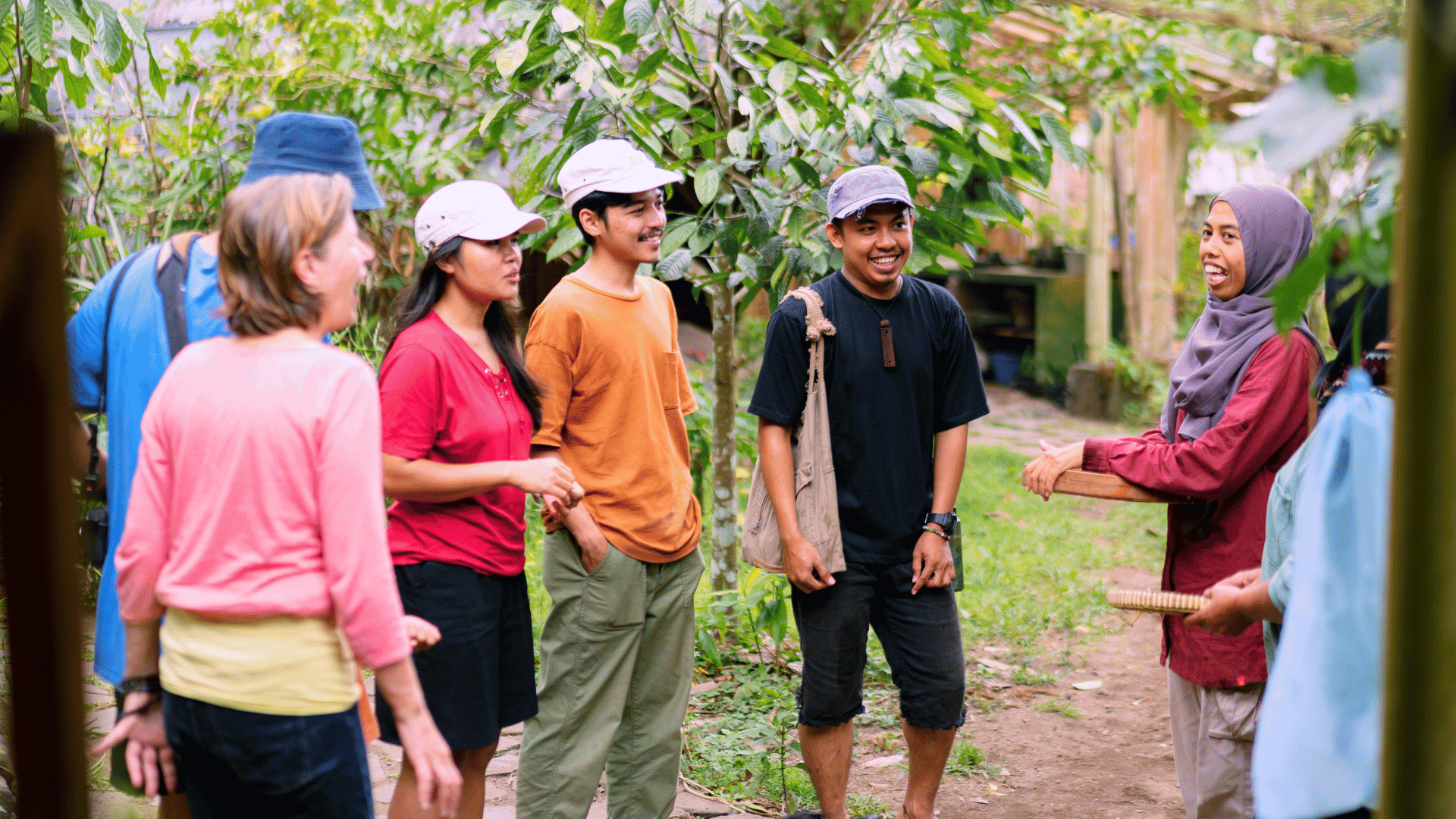 Group of people engaging in outdoor discussion about sustainable tourism in a lush, green setting.