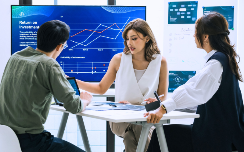 A team of financial executives analysing digital financial data and strategy in a modern office