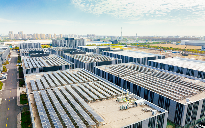Aerial view of solar panels on factory roof.