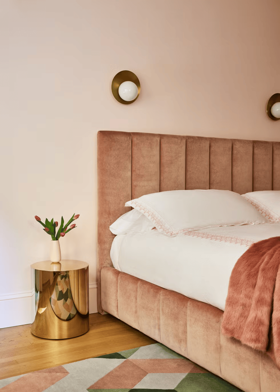 A blush-toned bedroom radiates softness and sophistication with velvet textures and brass accents