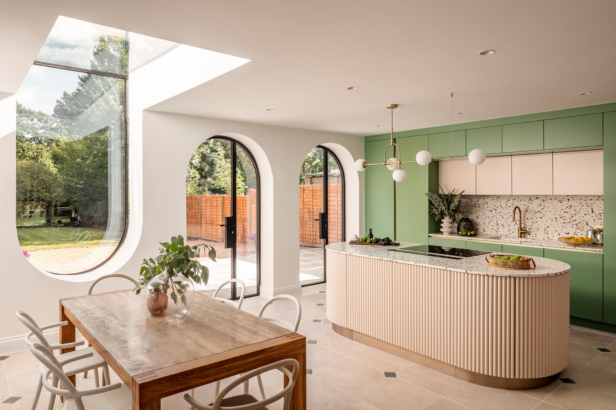 A playful blend of curves and pastels in this kitchen–dining space evokes Art Deco elegance with a modern twist
