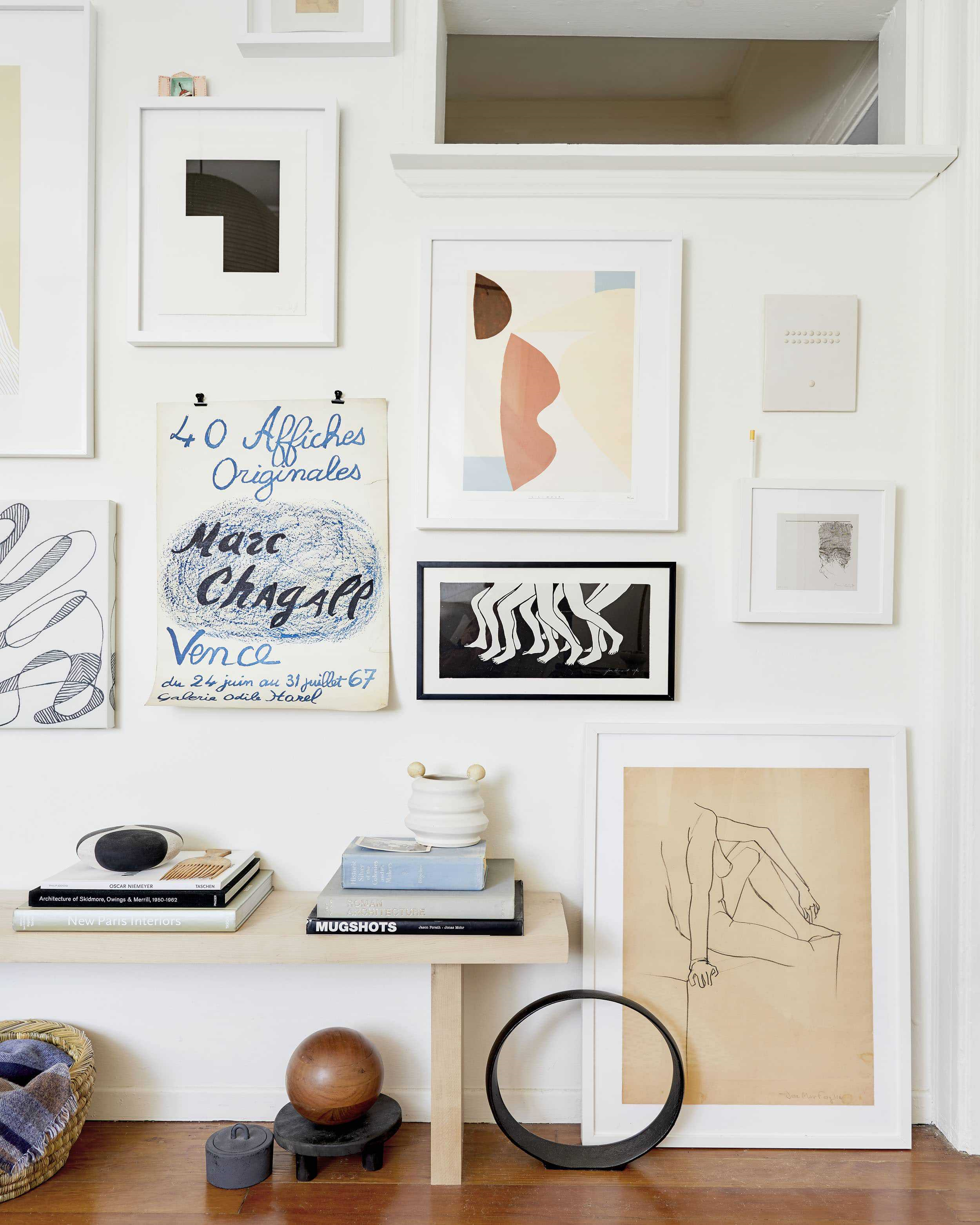 A curated gallery wall anchors this eclectic space, where books, art, and design objects blend into a lived-in display