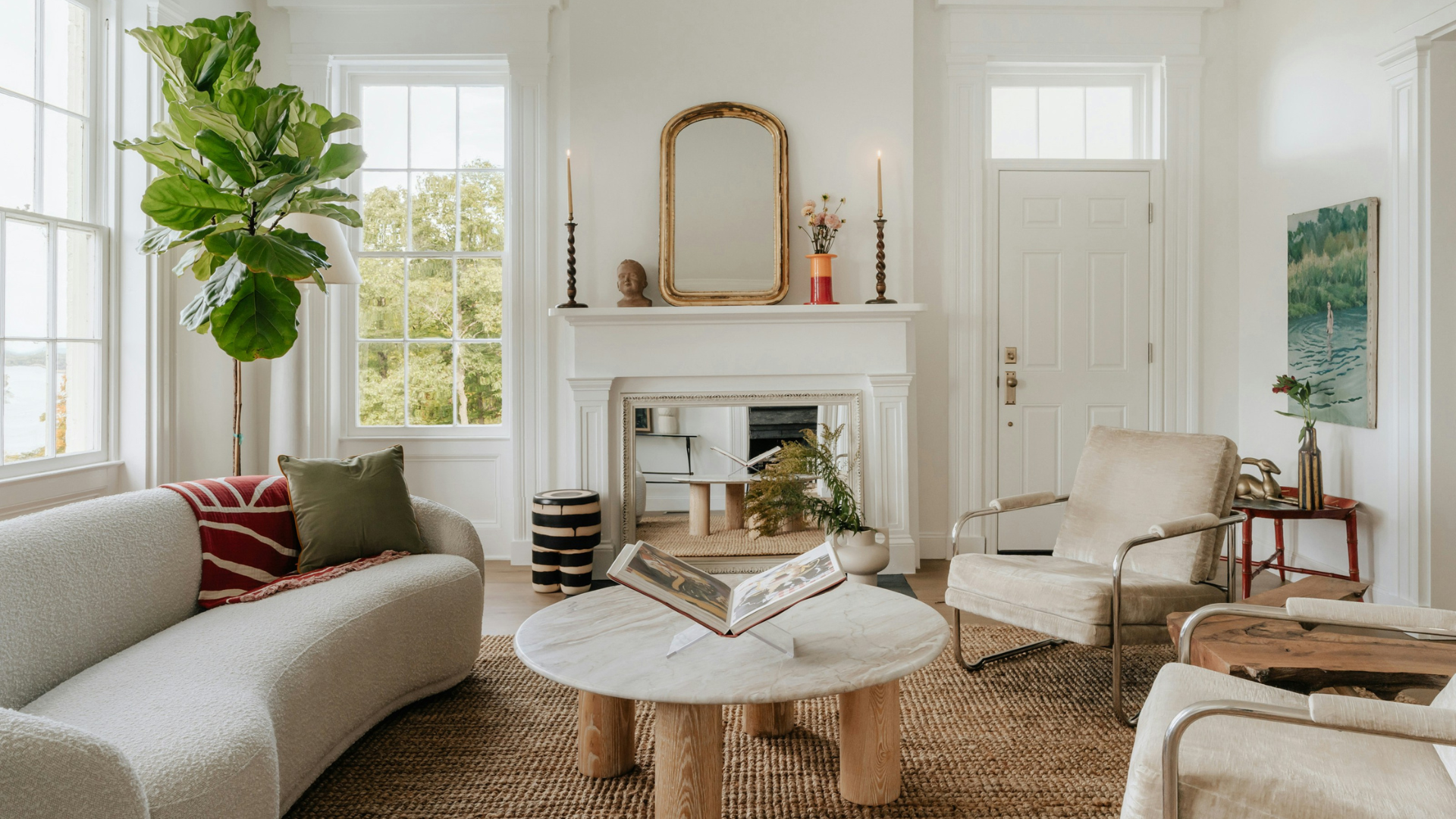A light-filled living room that blends classical architecture with balanced asymmetry in its furniture and decor.