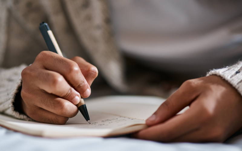 Person writing on a physical planner