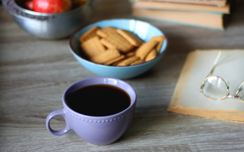 A cup of coffee and snacks on a table