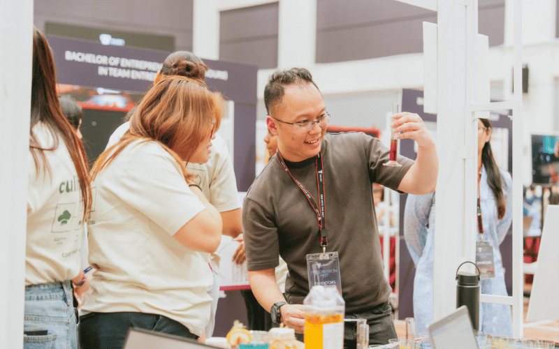 Visitor experimenting with test tube at Progression Fest 2025
