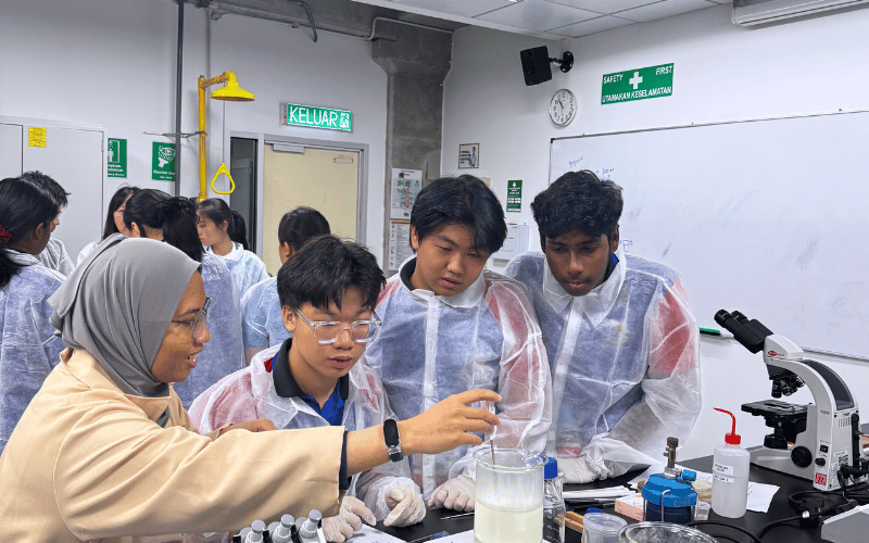 Lecturer demonstrating to high school students in a science lab