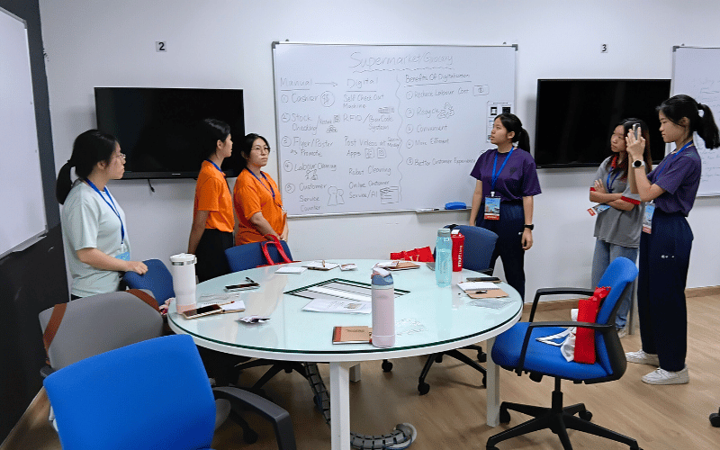 A group of female students are ready to do their presentation in the classroom space. 