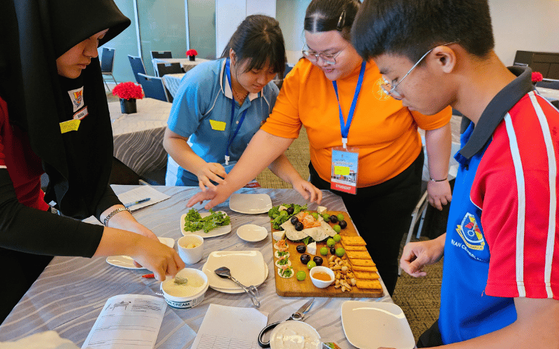 A diverse students gather together to create food presentation