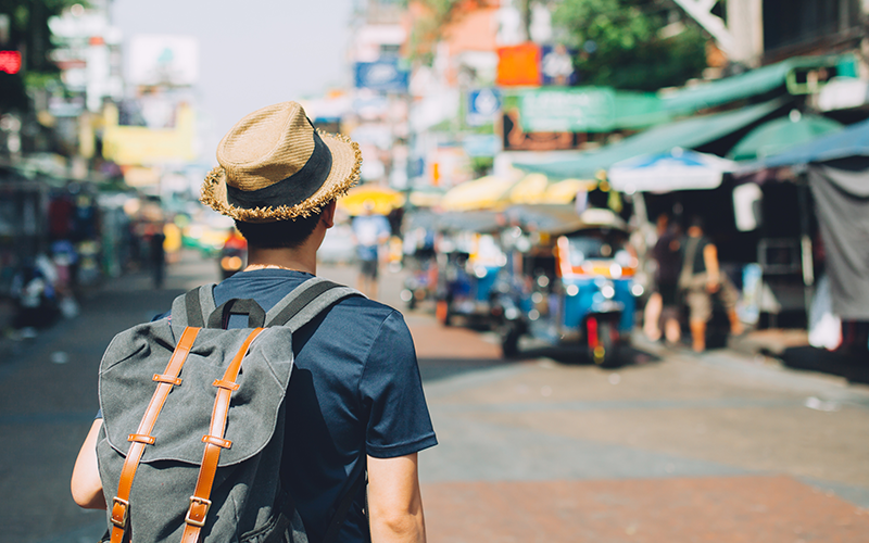 oung Asian traveling backpacker in Khaosan Road outdoor market in Bangkok, Thailand