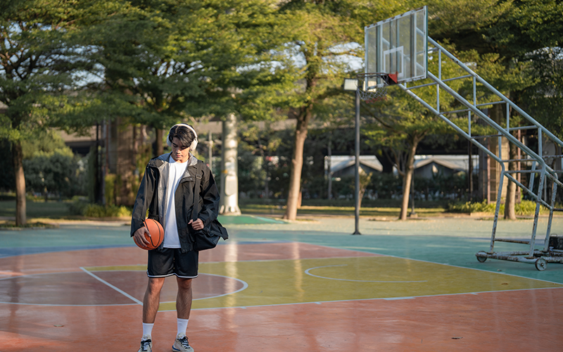 Young asian guy at basketball court