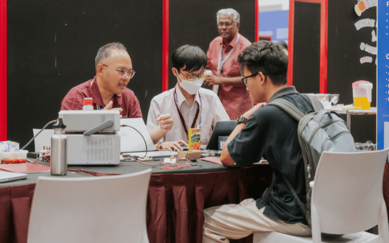 Lecturers giving advice to student at the booth