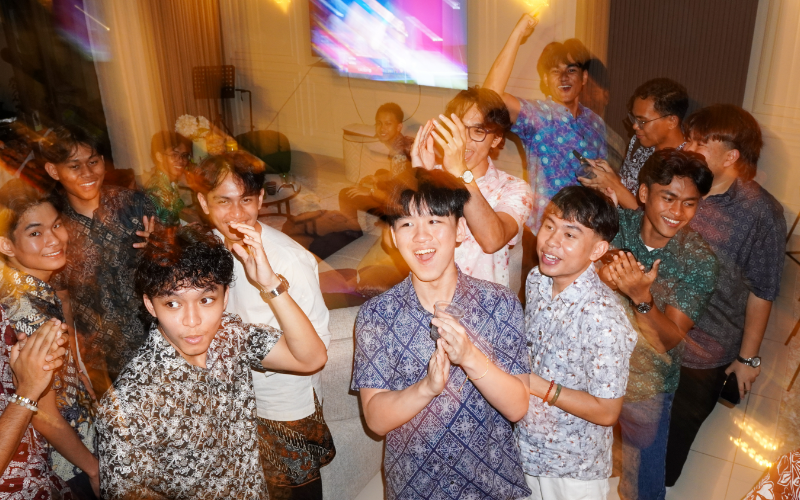 A group of friends celebrating together indoors, captured with a motion-blur effect.
