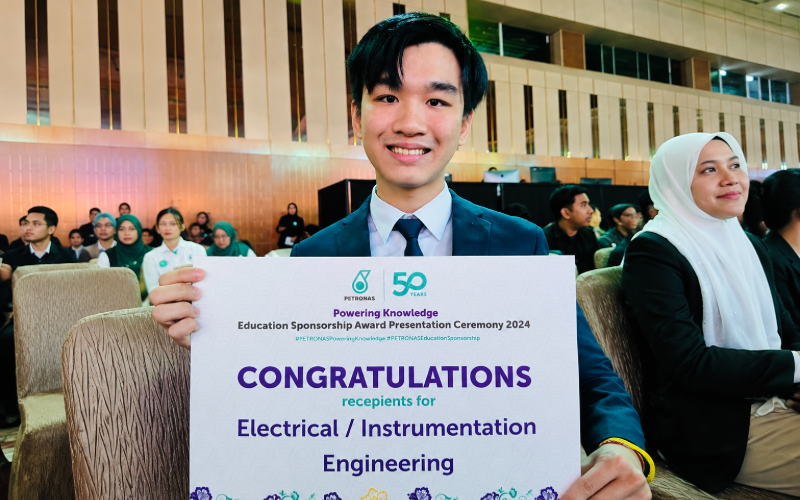 Justin holding a certificate at an engineering education sponsorship award ceremony recognising Electrical/Instrumentation Engineering recipients.