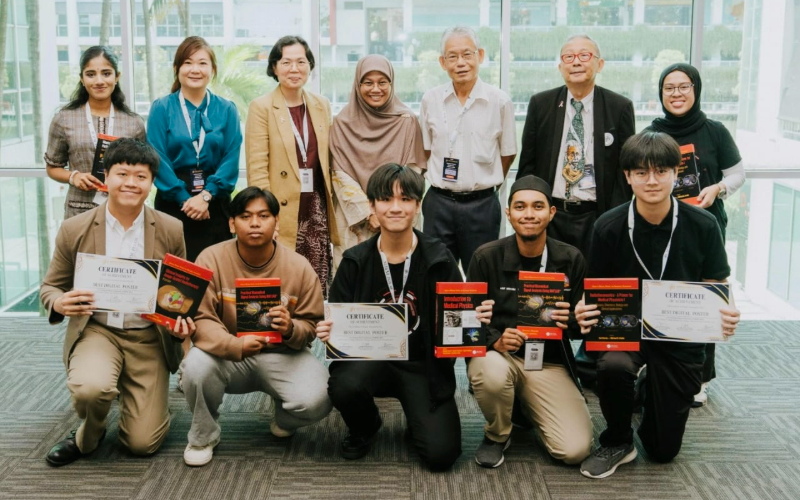 Justin with fellow award recipients and event guests, each holding certificates and books at an awards ceremony.