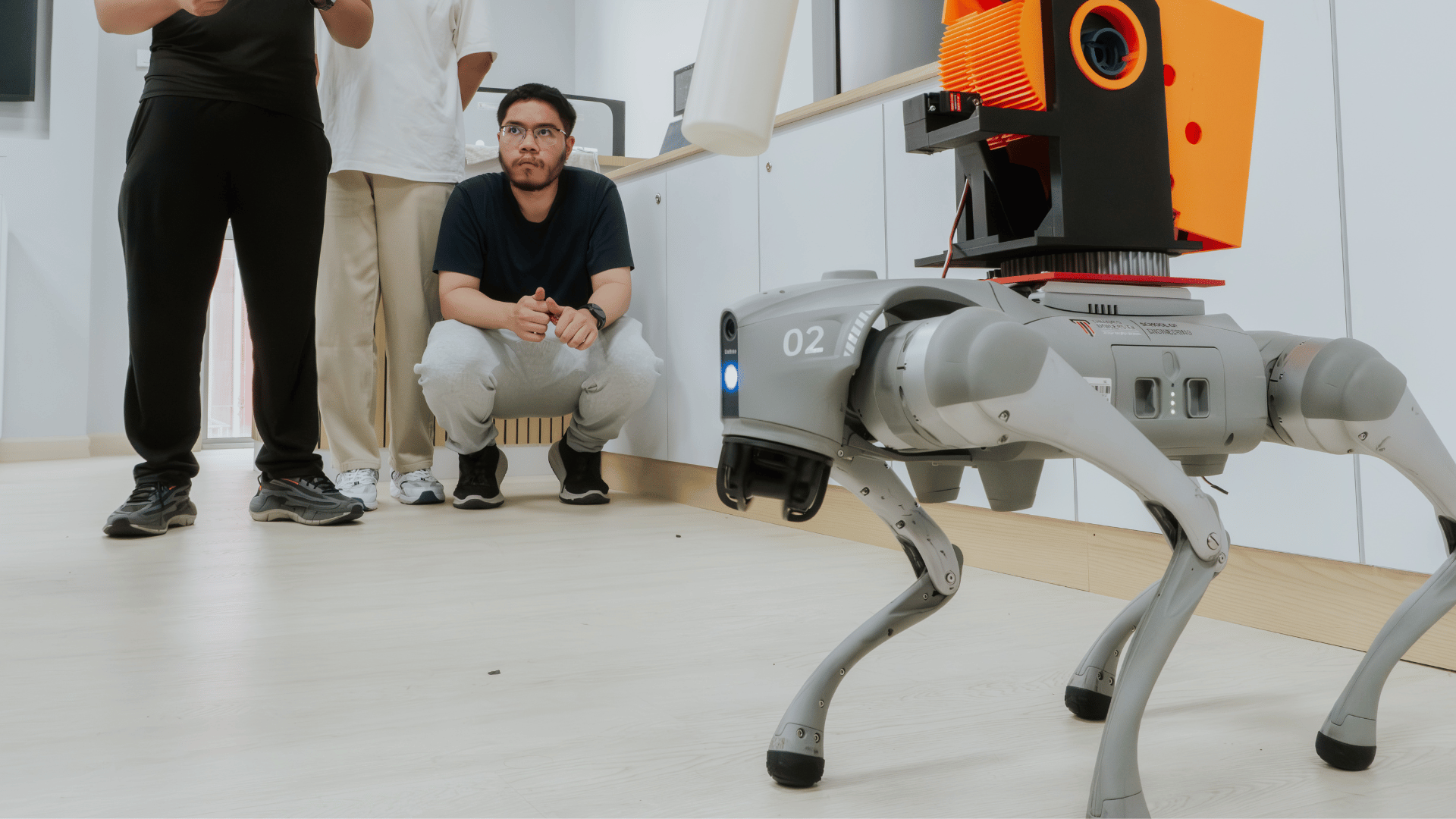 Students observing a robotic quadruped during an engineering demonstration