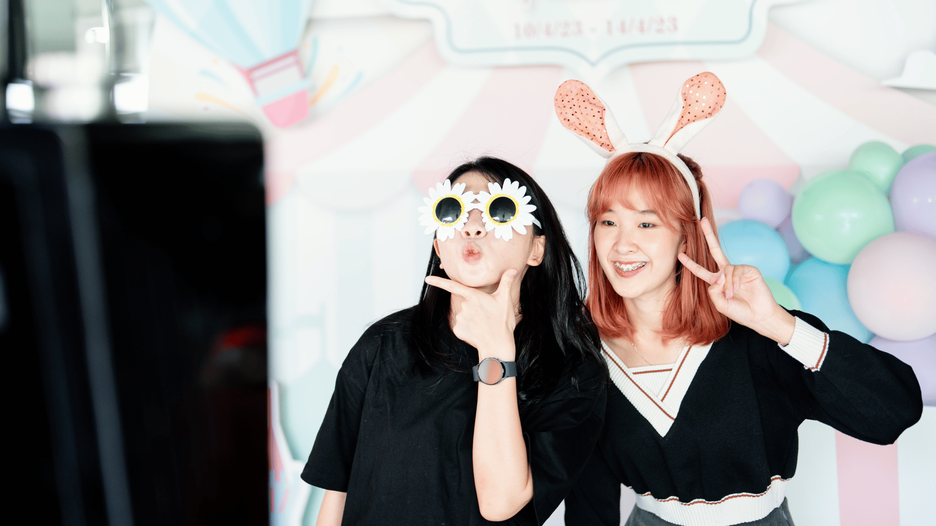 Two students strike cute poses in front of camera