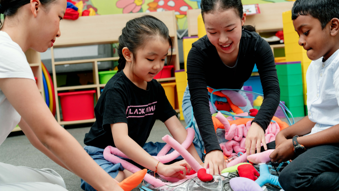 Female teacher engages with pre-school kids for interactive game