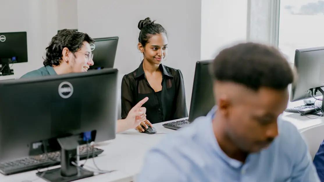 Student looks at the desktop while interacts with her peer