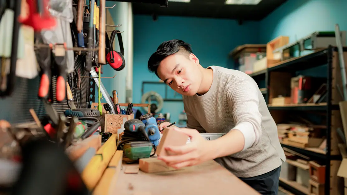 Student looks at the wooden block for his crafting project