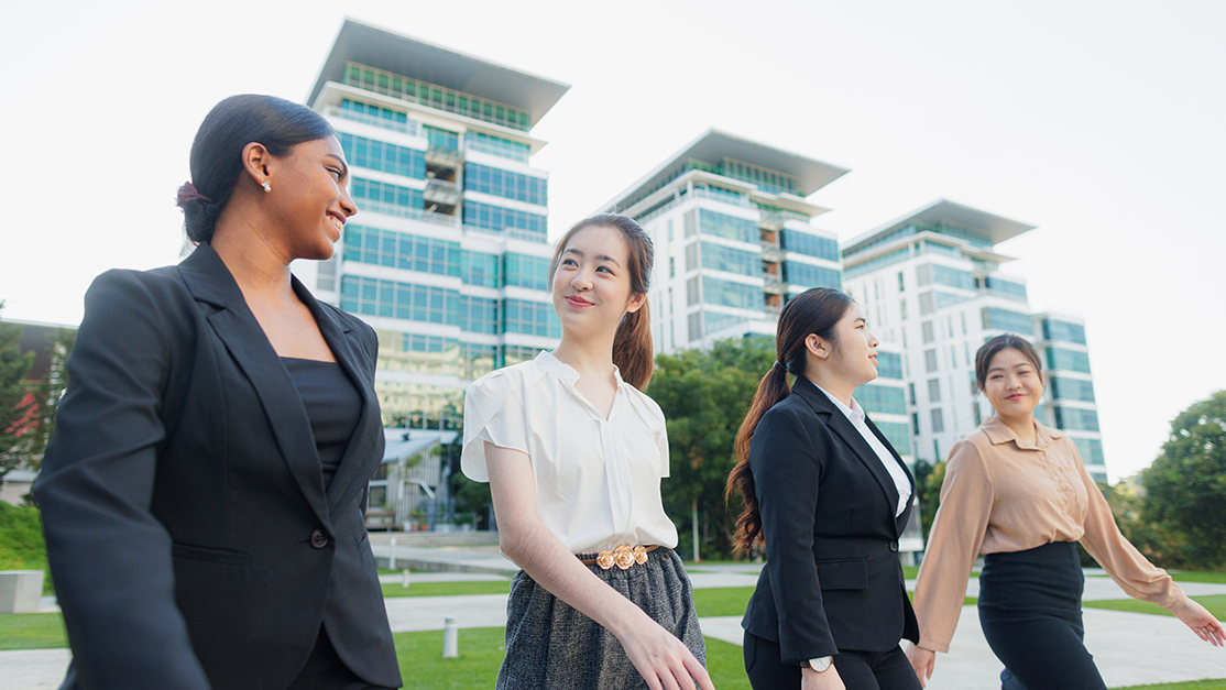 4 ladies in formal wear walks proudly in front of Taylor's building