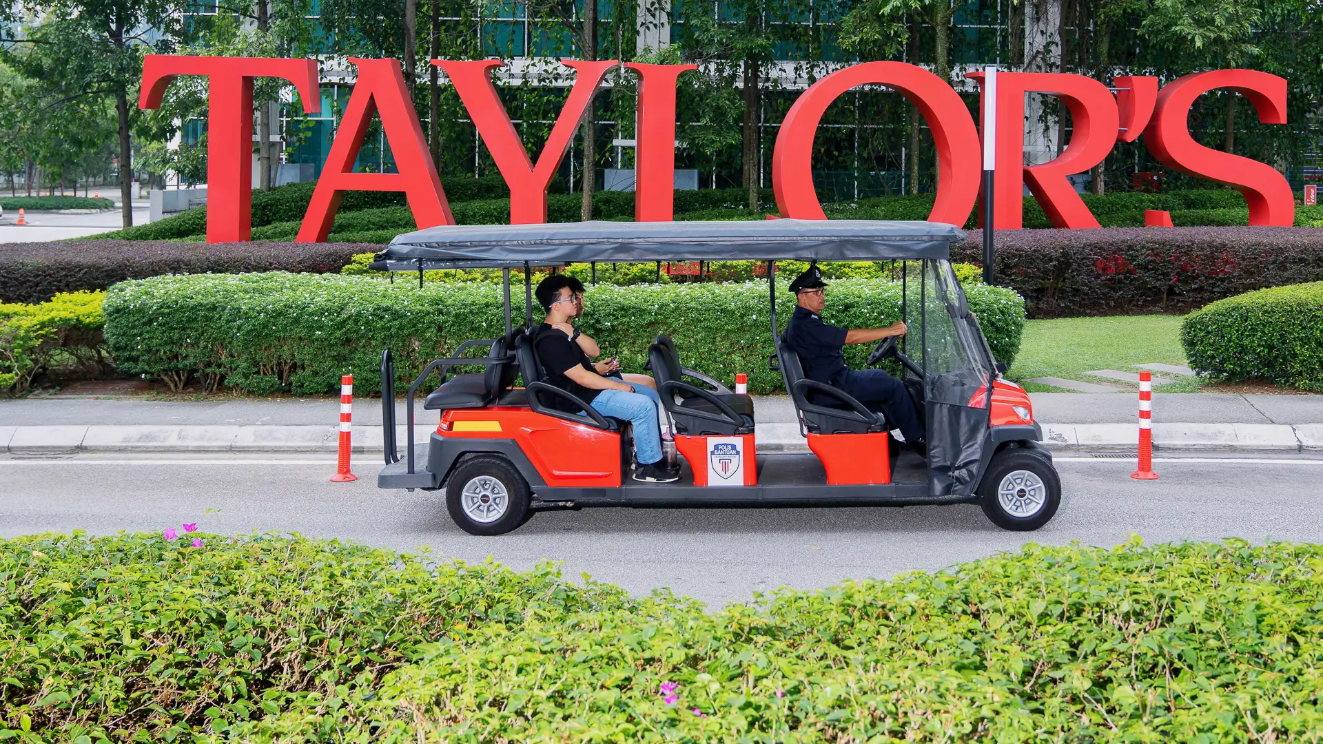 Passenger sitting in a buggy passing by Taylor's signage