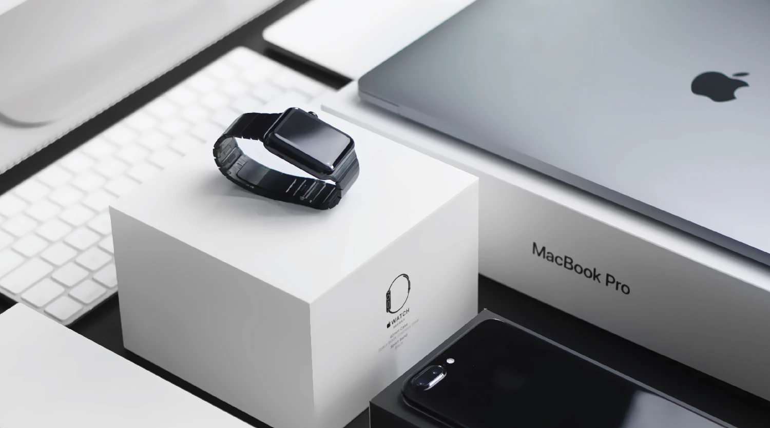 a smart watch placed beside a laptop