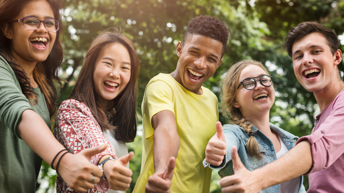 a group of multiracial friends giving the thumbs up