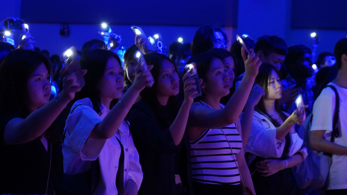 concert goers flashing their flashlights
