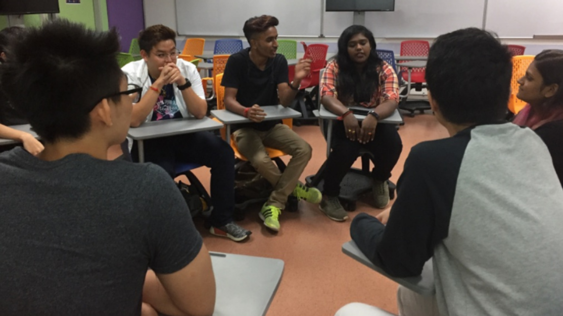 students huddled up seated in a circle